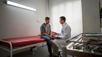 Разговор в стационаре Мужчина сидит в стационаре